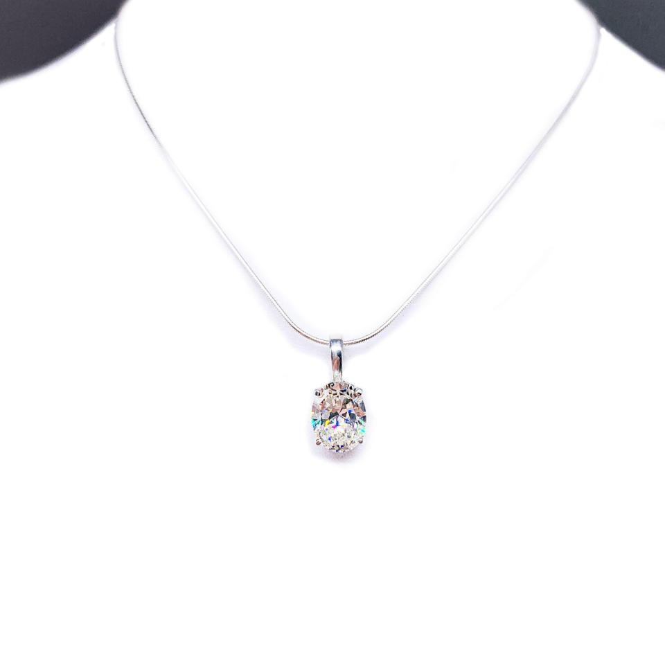 Sterling silver necklace featuring an oval near-colorless cubic zirconia pendant in a four-prong setting with single bail, shown on a sterling silver chain.