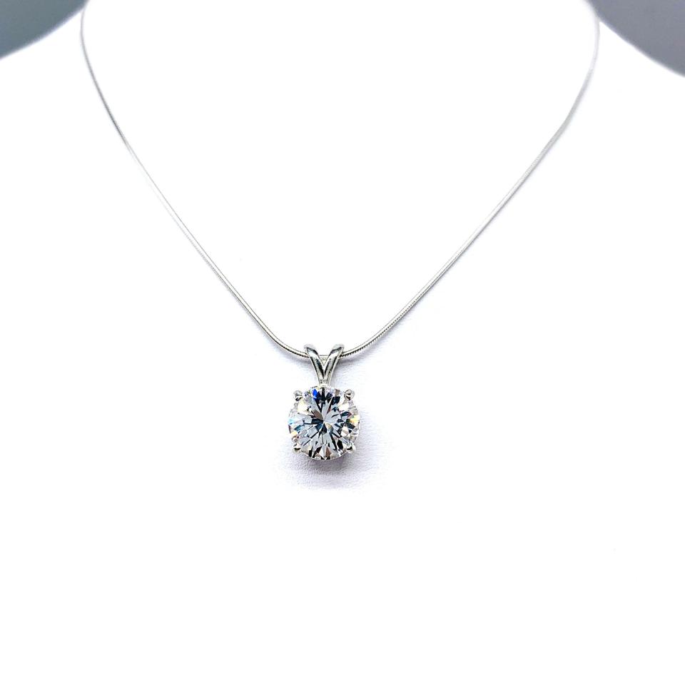 Sterling silver necklace featuring a round lab-created white sapphire pendant in a 4-prong setting, available in five sizes.