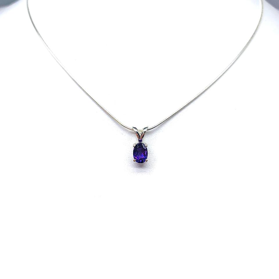 Sterling silver necklace featuring a natural African amethyst pendant in an oval cut, secured by a four-prong setting and displayed on a sterling silver chain.