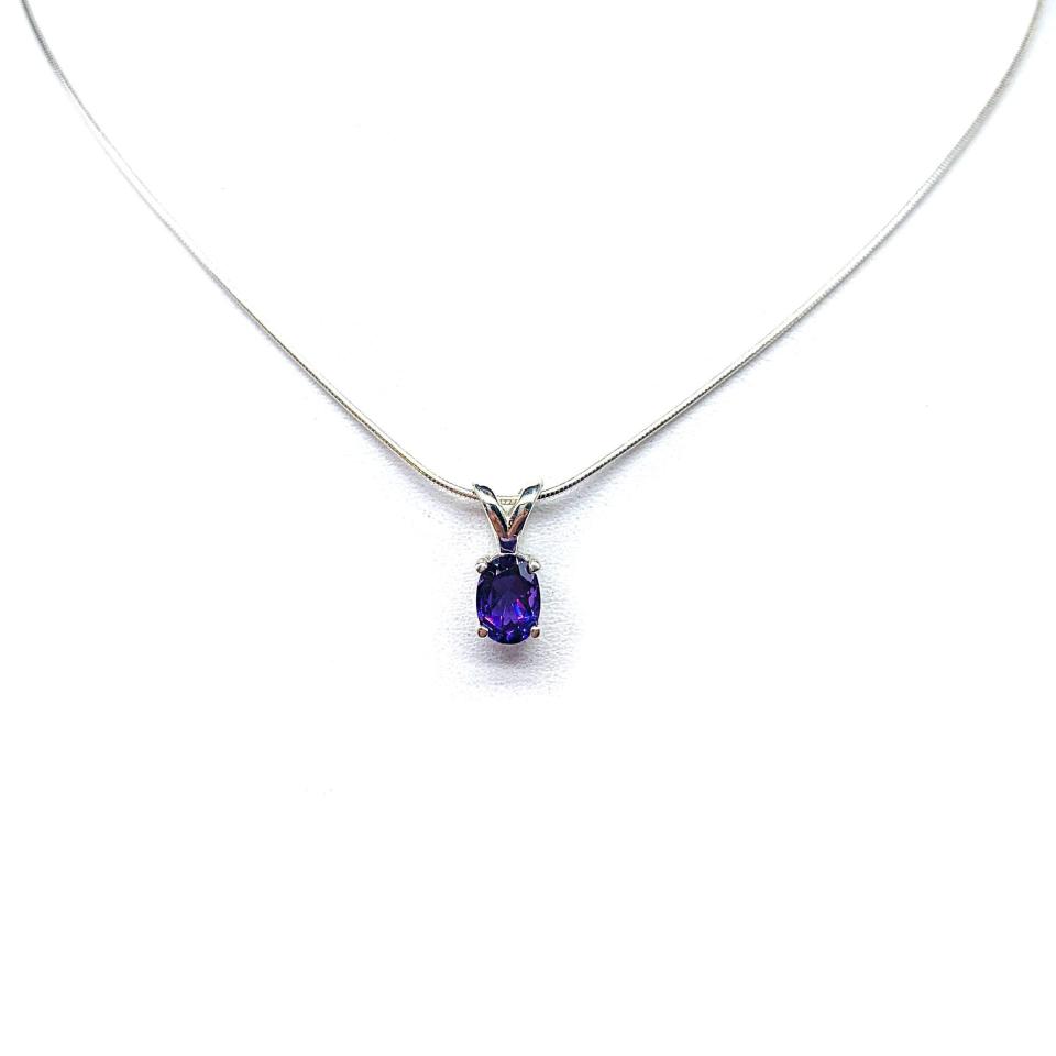 Sterling silver necklace featuring a natural African amethyst pendant in an oval cut, secured by a four-prong setting and displayed on a sterling silver chain.