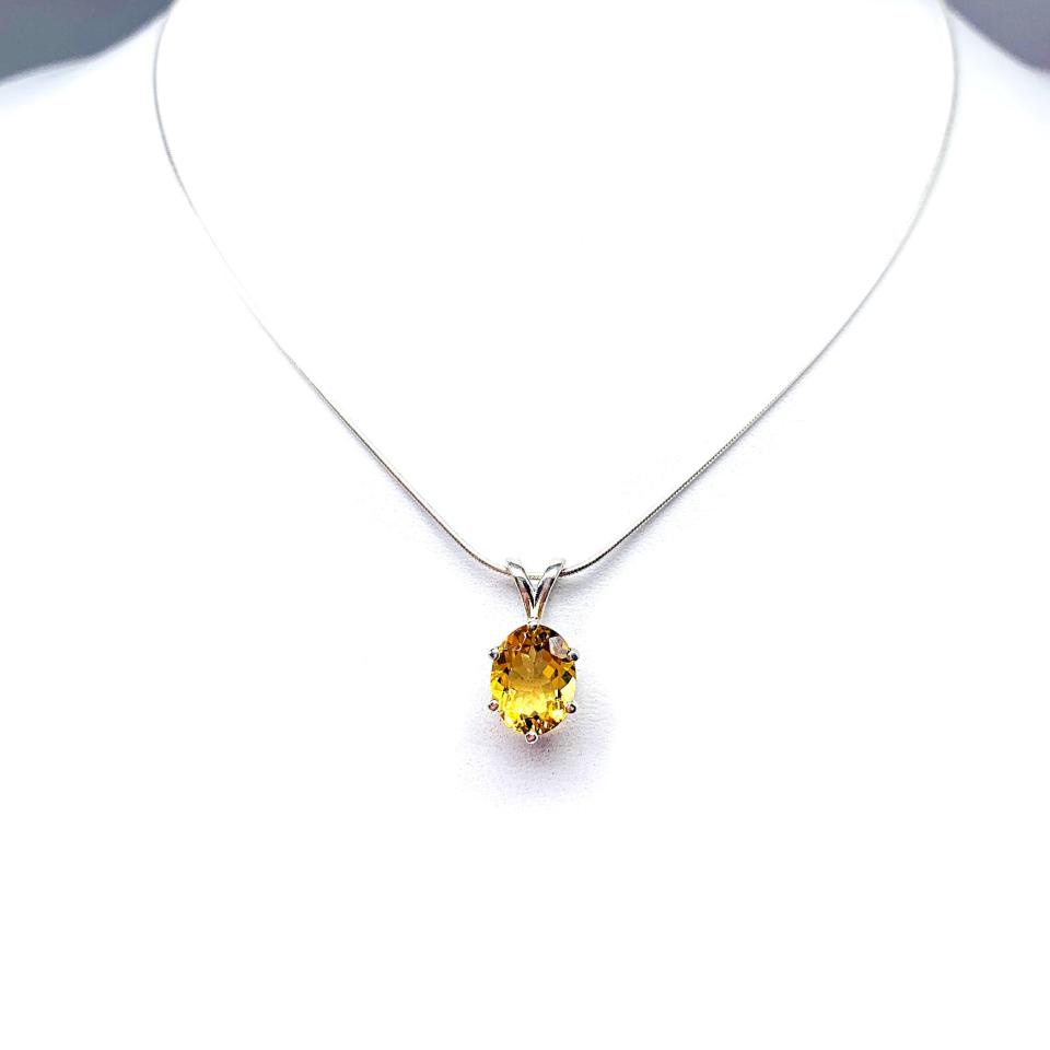 Sterling silver necklace with a 10x8mm oval-cut golden citrine pendant in a 6-prong setting, displayed against a white background.