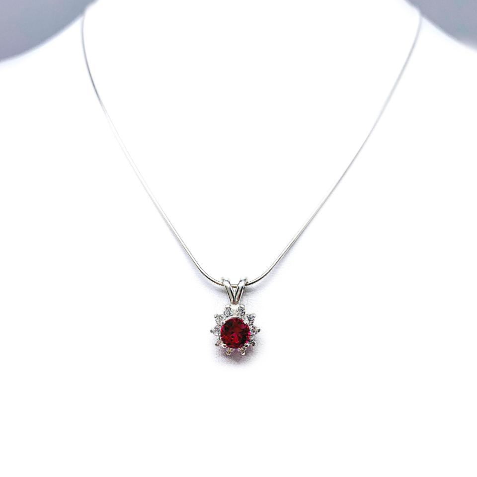 Sterling silver halo pendant necklace featuring a round vivid deep red lab ruby center stone (5mm–8mm), surrounded by small CZs in a floral-inspired setting on a delicate silver chain.