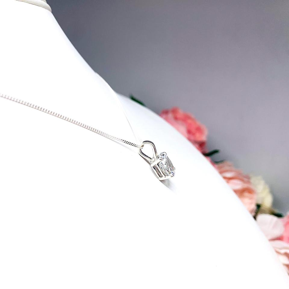 Sterling silver necklace featuring an oval cubic zirconia pendant in a four-prong setting with single bail, shown on a sterling silver chain.