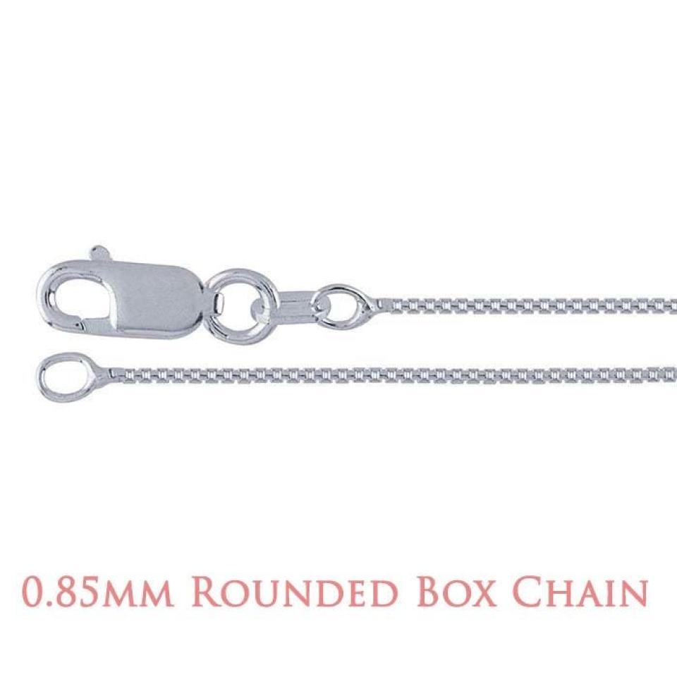 A close-up image of a delicate silver chain with a lobster clasp closure. The chain features a rounded box link design, where each small, square-shaped link has softly curved edges that create a smooth, reflective surface. The overall appearance is sleek and polished, highlighting the fine craftsmanship and subtle shine of the metal. Text at the bottom of the image reads “0.85mm Rounded Box Chain” in a soft rose-colored font.