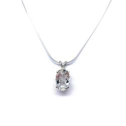 Close-up of a white topaz oval pendant necklace featuring a faceted natural gemstone in a sterling silver prong setting, suspended from a delicate sterling chain. Available in five stone sizes.