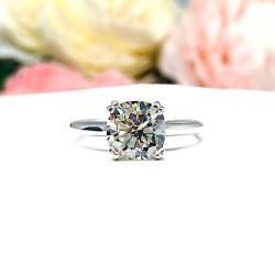 Close-up of a sterling silver cathedral-style engagement ring featuring an 8mm near colorless cushion cut cubic zirconia center stone. The ring is shown facing forward, showcasing the brilliant faceting of the center stone and split prongs.